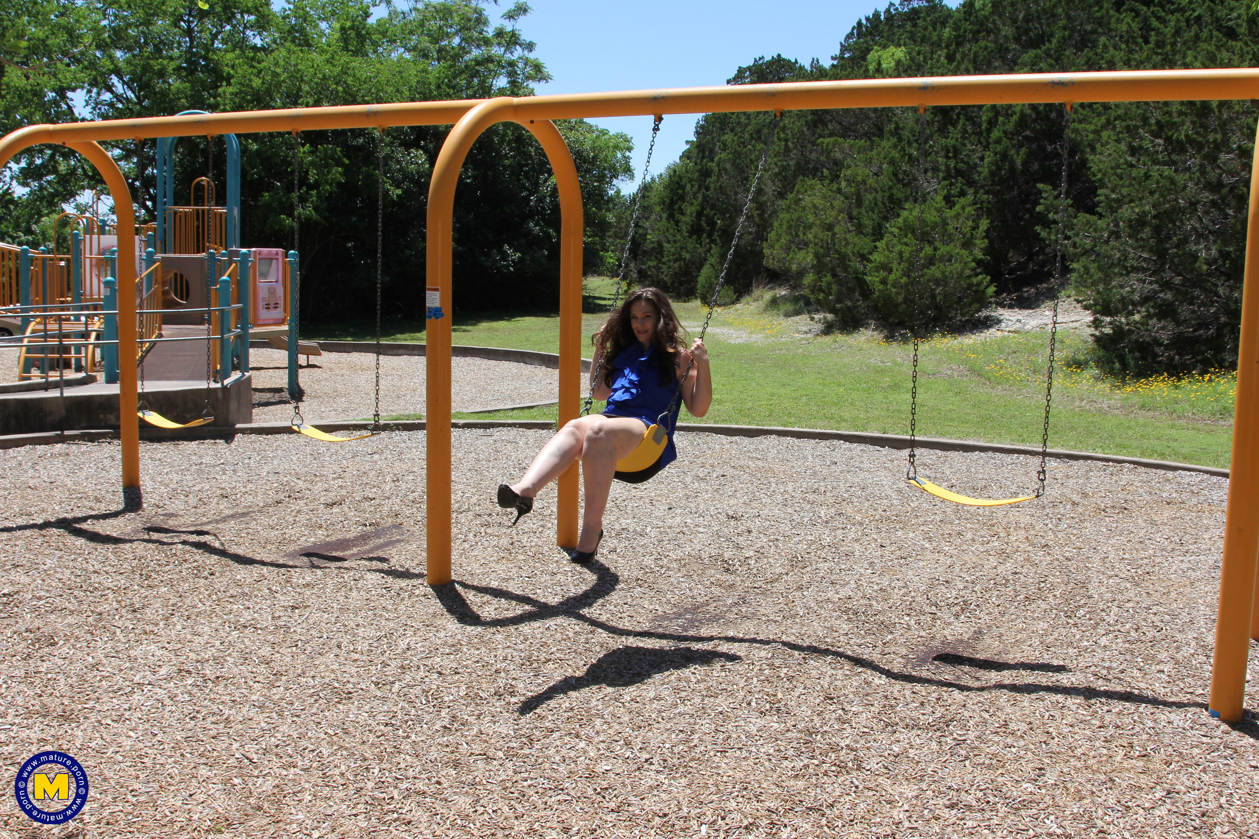 Mature with naked pussy under tight skirt riding on a swing